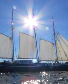 Sonne scheint auf das Segelschiff mit offenen Segeln