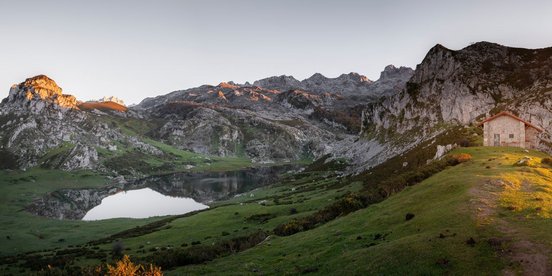 Bergsee spiegelt umgebende Gipfel im Morgenlicht