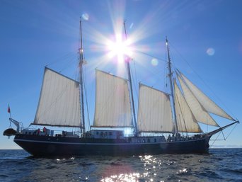 Sonne scheint auf das Segelschiff mit offenen Segeln