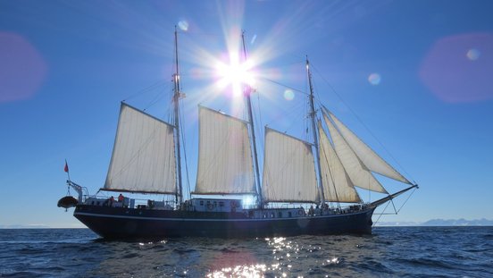 Sonne scheint auf das Segelschiff mit offenen Segeln