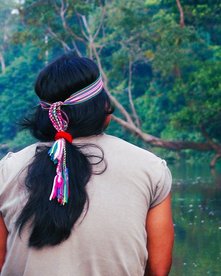 Ecuador Achuar Indianer mit Haarschmuck schaut auf einen Fluss im Amazonas