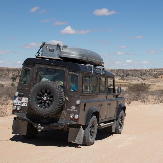 Auto von hinten mit Blick auf die trockene Landschaft Namibias