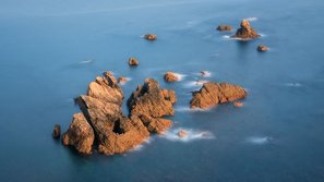 Felsen im Abendlicht ragen aus dem Meer