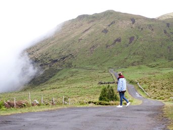 Frau auf einem Wanderweg im Hochland der Azoren