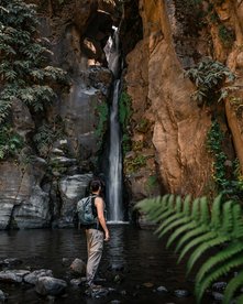 Mensch steht vor einem kleinen Wasserfall