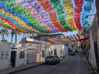 Bunte Fahnen zieren den blauen Himmel einer Straße der Altstadt San Joses in Baja California