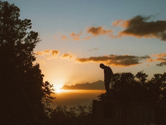 Mensch betrachtet Sonnenuntergang in Dominica