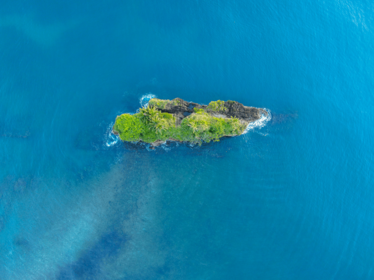 Kleine grüne Insel im blauen Meer