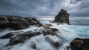 Langzeitbelichtung eines großen Felsens im Meer