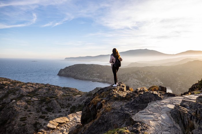 Frau wandert bei Sonnenuntergang am Cap de Creus in Spanien